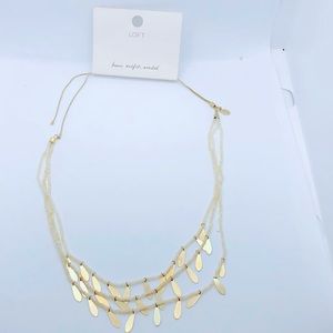 Loft necklace with white Jews and gold colored decorations.